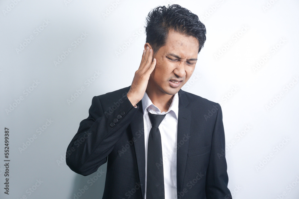Unhealthy young asian man suffering from sudden throbbing ear ache. Unhealthy young asian man suffering from sudden throbbing ear ache.