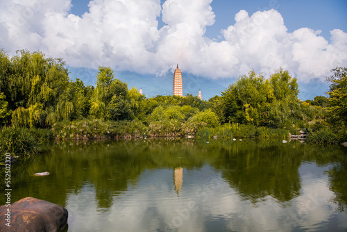 Scenic panorama of reflection park pond with the Three Pagodas and Cangshan mountains in background in Dali Yunnan China photo