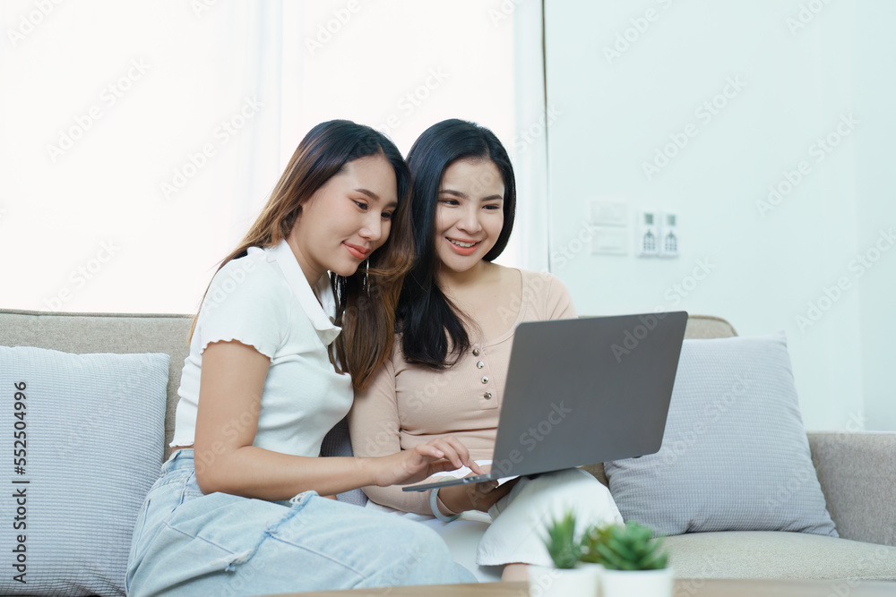 lgbtq, lgbt concept, homosexuality, portrait of two asian women posing happy together and loving each other while playing computer laptop on sofa lgbtq, lgbt concept, homosexuality, portrait of two asian women posing happy together and loving each other while playing computer laptop on sofa