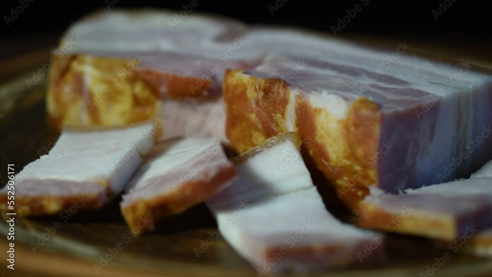 A large piece of ham, cut into pieces, lies on a plate that rotates.