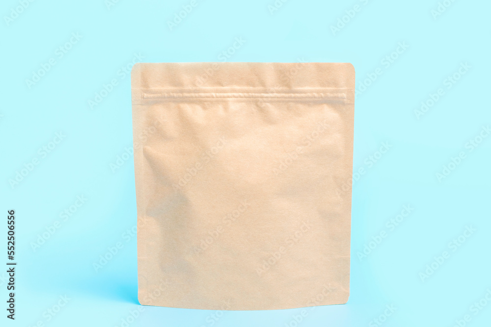 A brown kraft package close-up on blue background. A brown kraft package close-up on blue background.