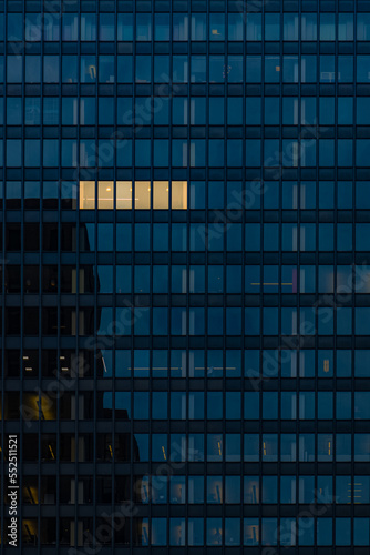Working late at night overtime, office building with one set of windows glowing
