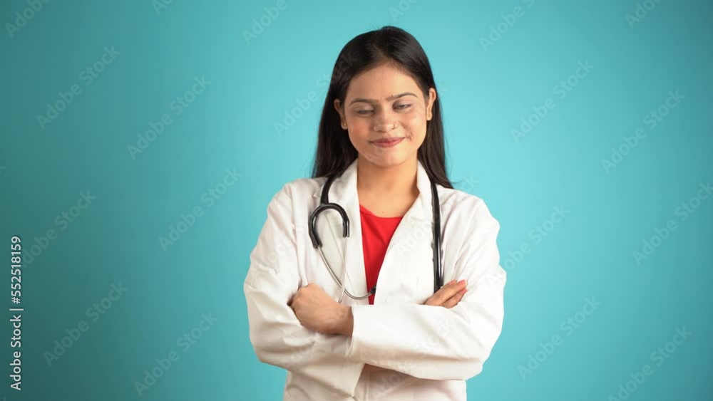 Portrait of a young female doctor wearing apron and stethoscope, Cheerful Asian Indian woman doctor isolated over blue studio background Portrait of a young female doctor wearing apron and stethoscope, Cheerful Asian Indian woman doctor isolated over blue studio background