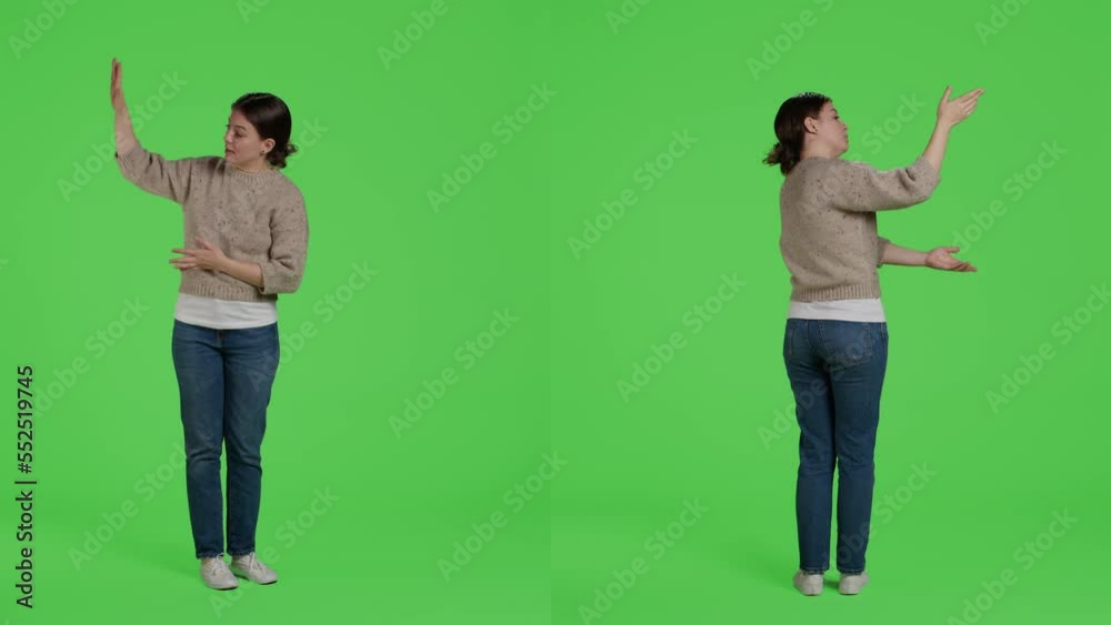 Friendly person doing advertisement and example sign in studio, standing over full body green screen backdrop. Casual relaxed woman showing presentation icon and advertising something. Friendly person doing advertisement and example sign in studio, standing over full body green screen backdrop. Casual relaxed woman showing presentation icon and advertising something.