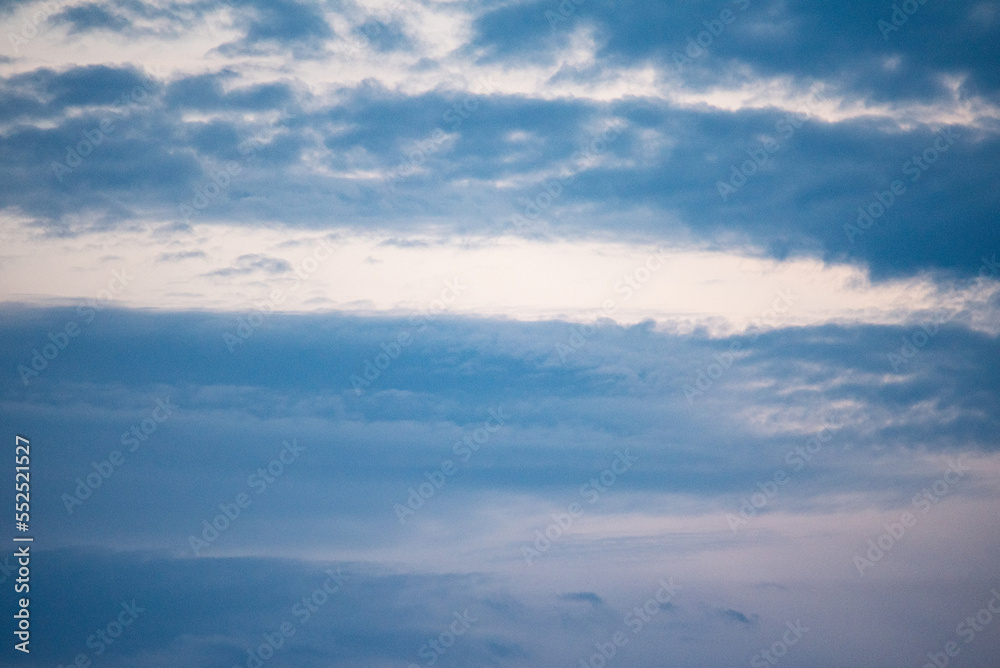 Blue sky with delicate white bands of clouds. Background of a slightly cloudy sky.