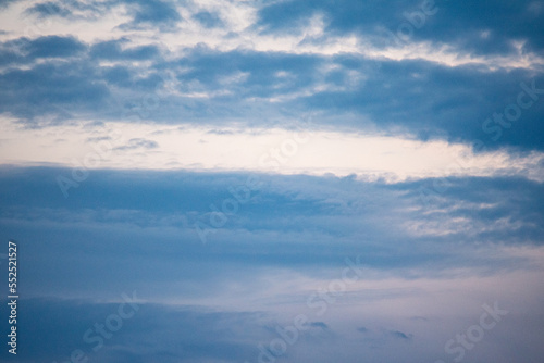 Blue sky with delicate white bands of clouds. Background of a slightly cloudy sky.