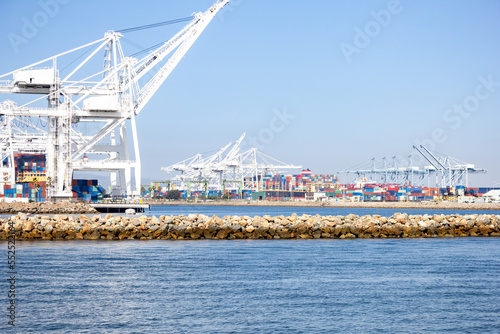 A view of several large loading cranes ready for unloading shipping containers off ships, in a local city port.