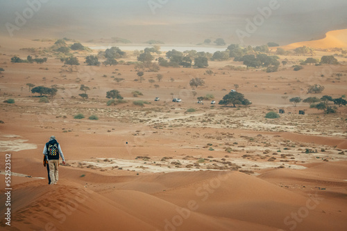 Touristin wandert   ber einen absteigenden Grat der D  ne Big Daddy hinab Richtung Parkplatz am Deadvlei  Sossusvlei  Namibia