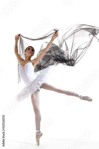 Dance Concepts. Professional Asian Japanese Female Ballet Dancer in White Tutu With Black Flying Cloth and Lifted Hands Against White Background.