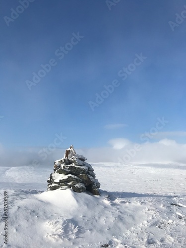 snowy stone cairn at mountain top