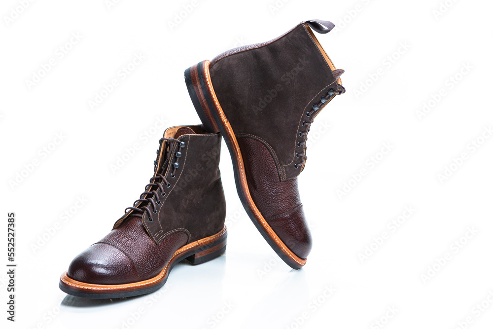 Footwear Ideas. Premium Dark Brown Grain Brogue Derby Boots Made of Calf Leather with Rubber Sole Placed on One Another Over White Background.