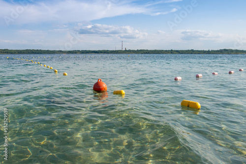 A floating buoy on the top of the lake on a sunny day. Navigational devices. Safe water marks