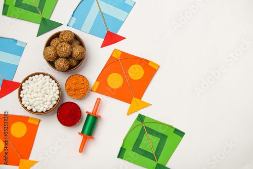 Happy Makar Sankranti, Pongal and Uttarayan with Kite, haldi kum kum bowls and tilgul sweets photo