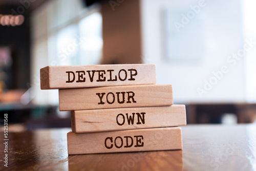Wooden blocks with words 'Develop your own code'.