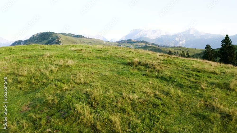 Slow Ground Revealing Shot Of Wooden Mountain Village, Small Huts, Tourist Shepherd Houses Standing on Top Of The Mountain Big Pasture Plateau With Alps in The background and Beautiful Green Meadow, Slow Ground Revealing Shot Of Wooden Mountain Village, Small Huts, Tourist Shepherd Houses Standing on Top Of The Mountain Big Pasture Plateau With Alps in The background and Beautiful Green Meadow,