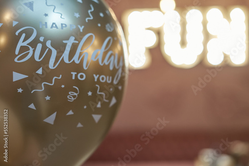 Illumination from the sign on the wall: "fun". Birthday balloons from the side.