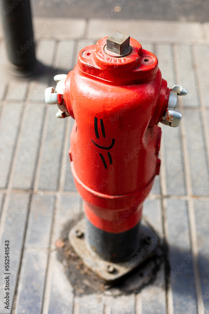 red fire hydrant with a happy face graffiti red fire hydrant with a happy face graffiti