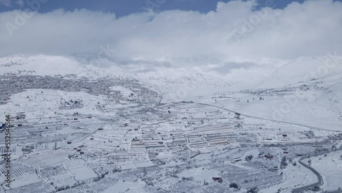 Establishing shot a snowy Ramat Hagolan with Mount Hermon covered with clouds photo