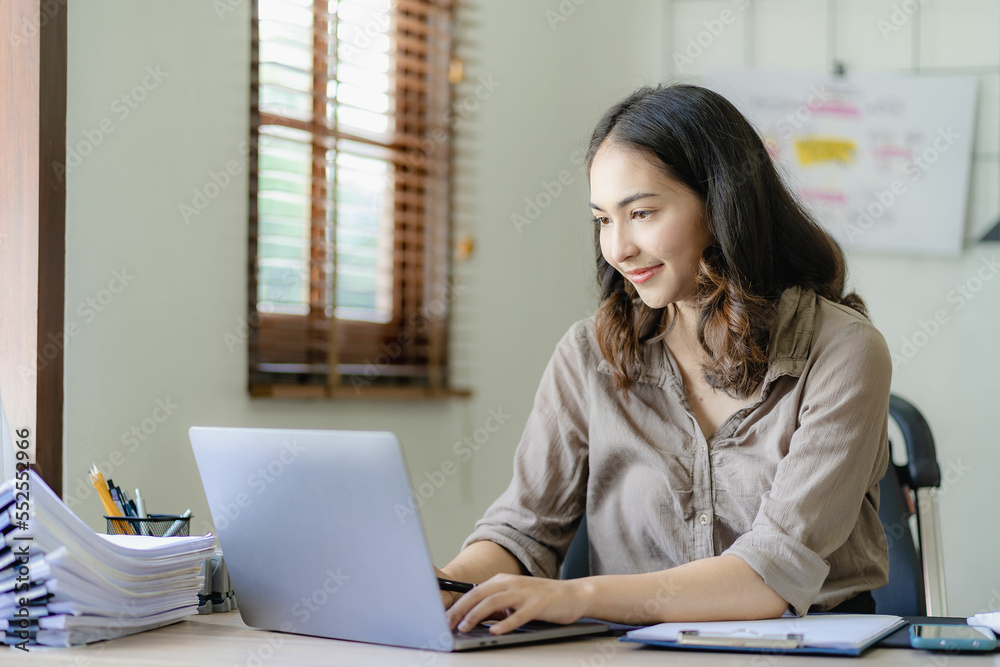 Asian businesswoman handling accounting tasks Accounting group meeting online and using laptop computer Professional confident employees in the office Asian businesswoman handling accounting tasks Accounting group meeting online and using laptop computer Professional confident employees in the office