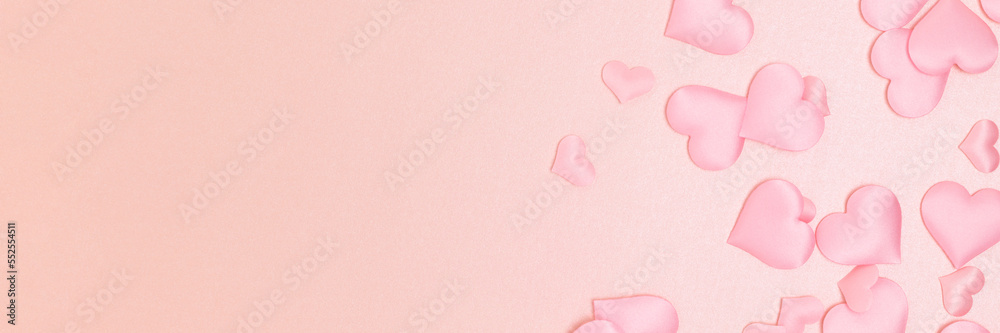 Banner with textile hearts confetti on a pink background. Place for text. Monochrome concept.