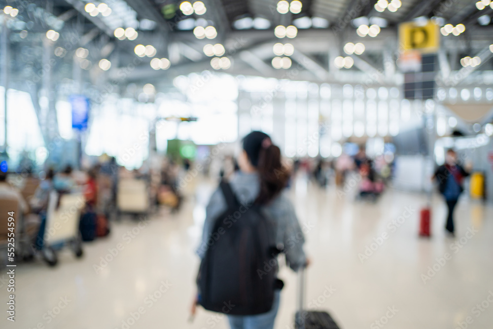 Blurred image of happy Asian woman with backpack and luggage standing on at international airport. Background image.