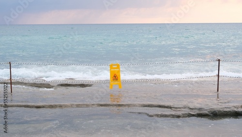 Slippery floor warning sign on the beach.
