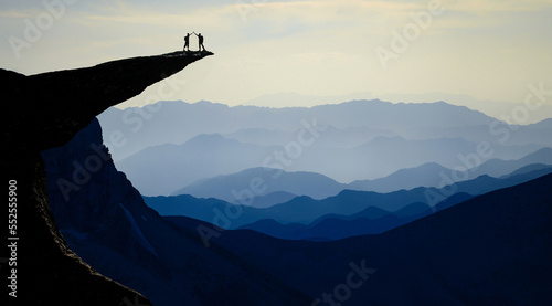 Successful duo on the summits of fascinating, mystical and impressive mountains photo