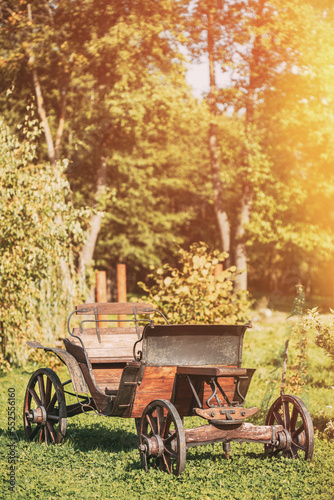 Decorative Yard Wagon On Summer Lawn. Bright Sunny Day. Gardening And Housekeeping. Vintage Cart On Summer Sunny Day. Garden Decoration Concept. Garden Wagon. Trolley. Old Wooden Cart. photo