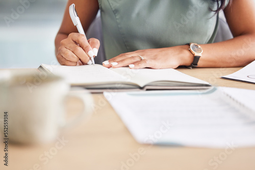 Hands, writing in notebook and planning for startup company, proposal and schedule. African American , black woman and entrepreneur make notes in book, journal and marketing strategy and ideas. photo