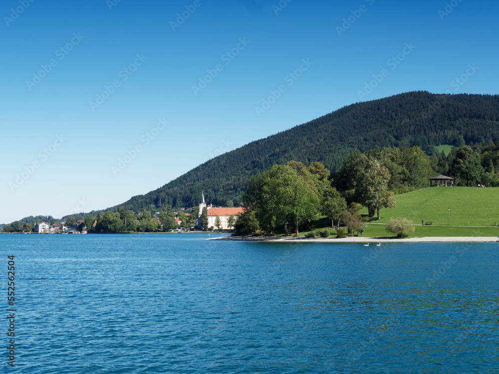 Tegernsee in Bavarian Alps. Promenade on the Shoreline of Rottach-Egern with view to the Benedictine monastery or Tergernsee Abbey tody a Schloss in Tegernsee