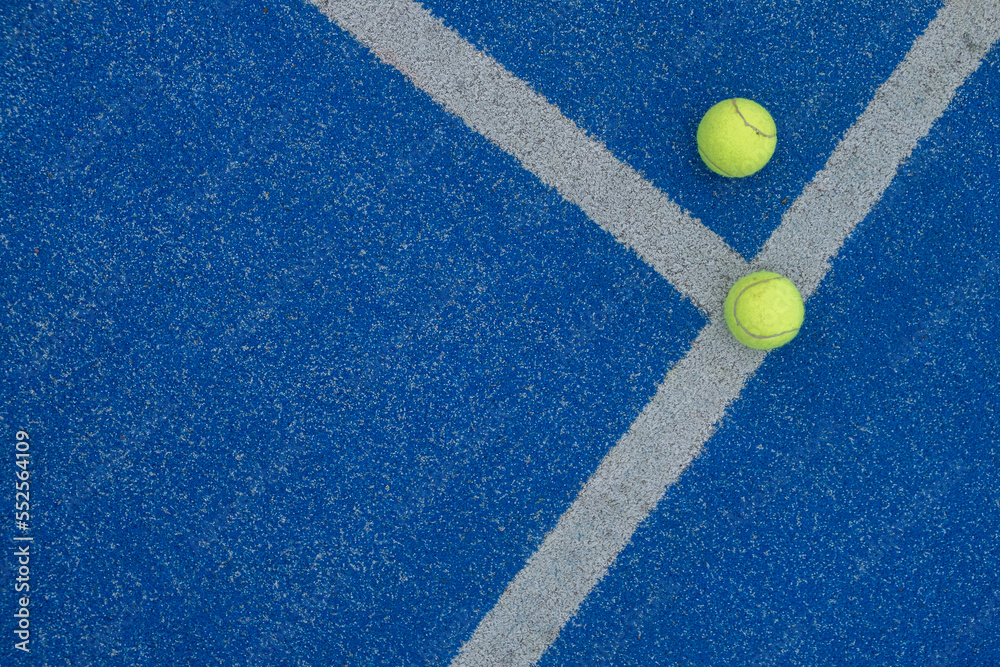 selective focus, two balls on a blue paddle tennis court where the lines meet. Racket sports