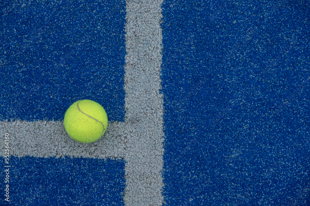 selective focus, ball on a blue paddle tennis court where the lines meet. Racket sports