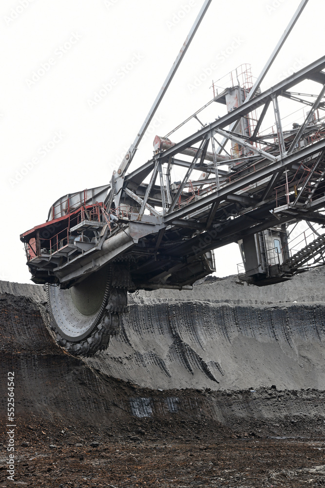 Fototapeta premium Bucket-wheel excavator during excavation at the surface mine. Huge excavator on open pit mine.