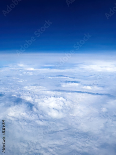 Aerial shot of cloudscape from airplane pov on sunny summer day