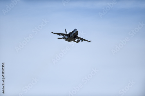 Military supersonic fighter jet with blue sky in the background