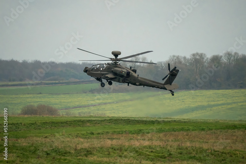 close up side view of British army AH-64E Boeing Apache Attack helicopter (ZM722 ArmyAir606) landing, autumn sky