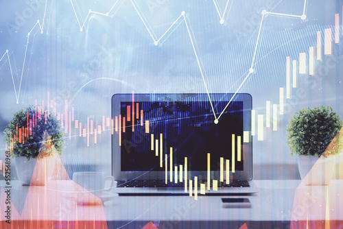 Stock market graph on background with desk and personal computer. Double exposure. Concept of financial analysis. © peshkova