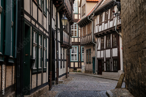 Quedlinburg, Saxony-Anhalt, Germany, 28 October 2022: Historic old vintage colored timber frame houses in medieval town, UNESCO World Heritage city, half-timbered home at sunny autumn day, cobblestone © AnnaRudnitskaya