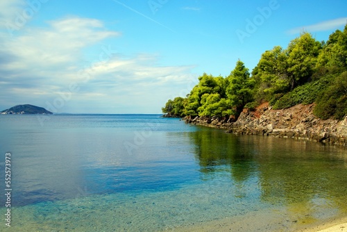 Recreation. View through the pine trees of the Aegean Sea in Sithonia. Greece. A warm sunny day in September. Bright colors and amazing beauty of nature.