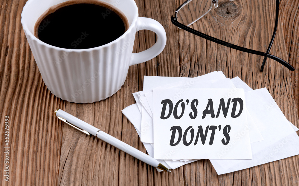 DO'S AND DONT'S text on sticky with coffee and pen on wooden background DO'S AND DONT'S text on sticky with coffee and pen on wooden background