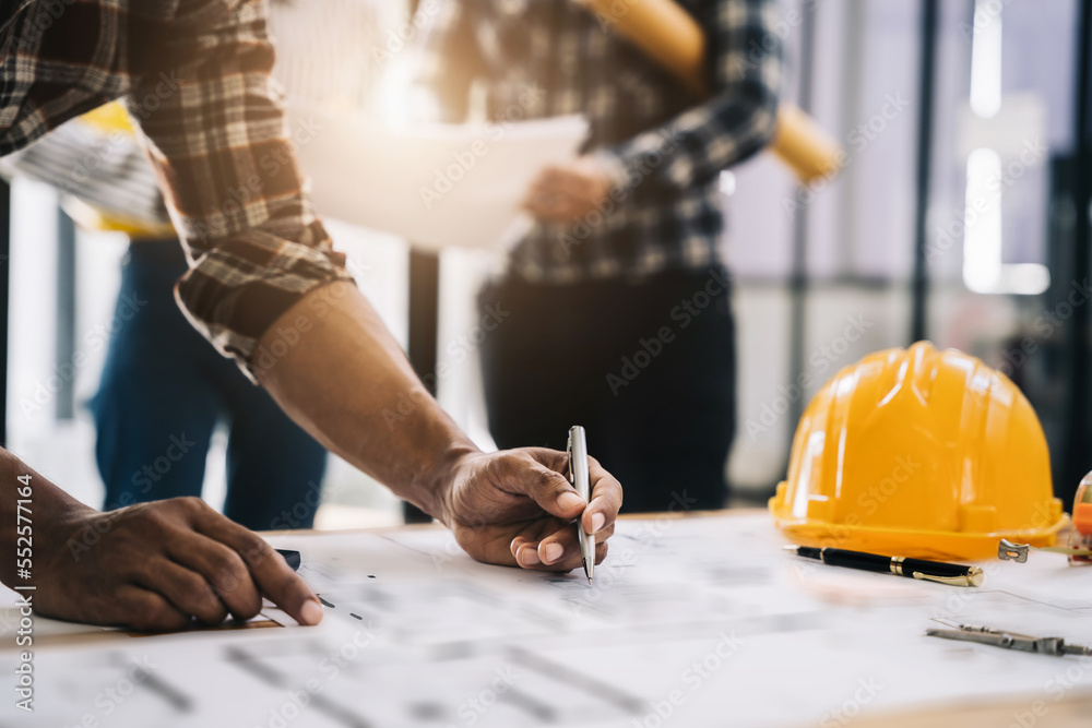 Concept architects or engineer holding pen pointing equipment architects on the desk with a blueprint in the office. Concept architects or engineer holding pen pointing equipment architects on the desk with a blueprint in the office.