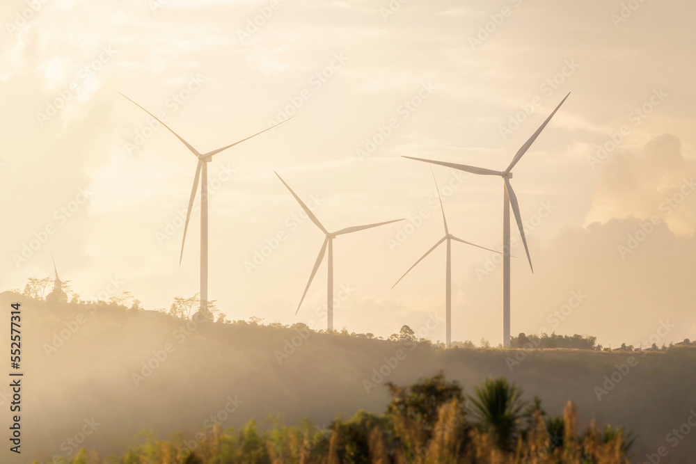 Clean and renewable energy to reduce carbon emissions concept, many wind turbines generating electricity on the mountain, smog in the morning. Clean and renewable energy to reduce carbon emissions concept, many wind turbines generating electricity on the mountain, smog in the morning.
