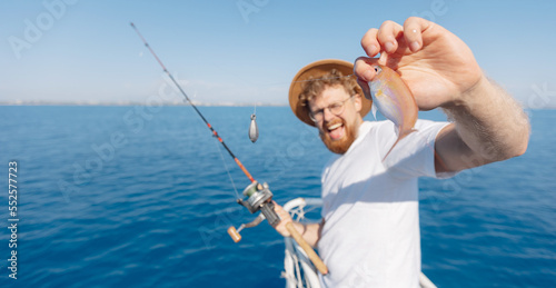 Tour fishing Turkey, Fisherman hipster tourist hold fish red mullet on boat in sea