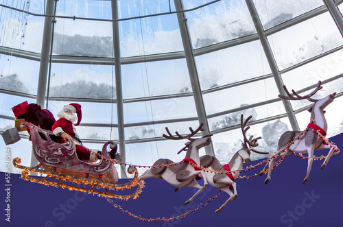 Santa on a sleigh with harnessed deer in the form of New Year's decorations, high above the dome of the building