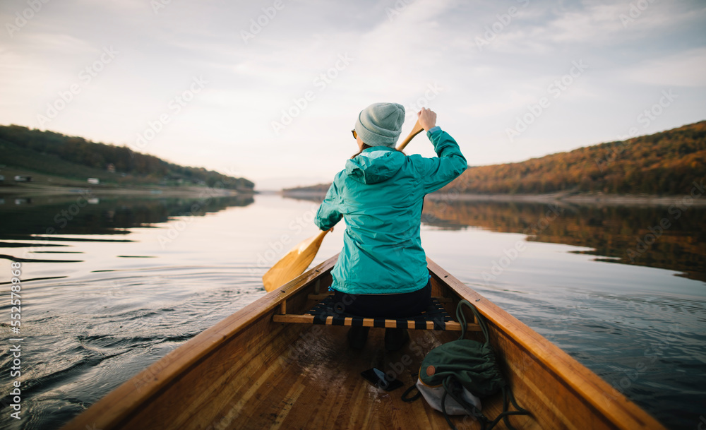 Rear view of woman paddling canoe
