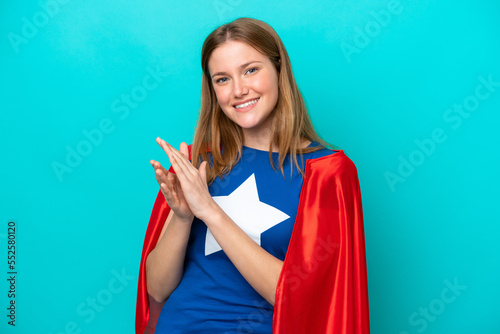 Super Hero caucasian woman isolated on blue background applauding after presentation in a conference