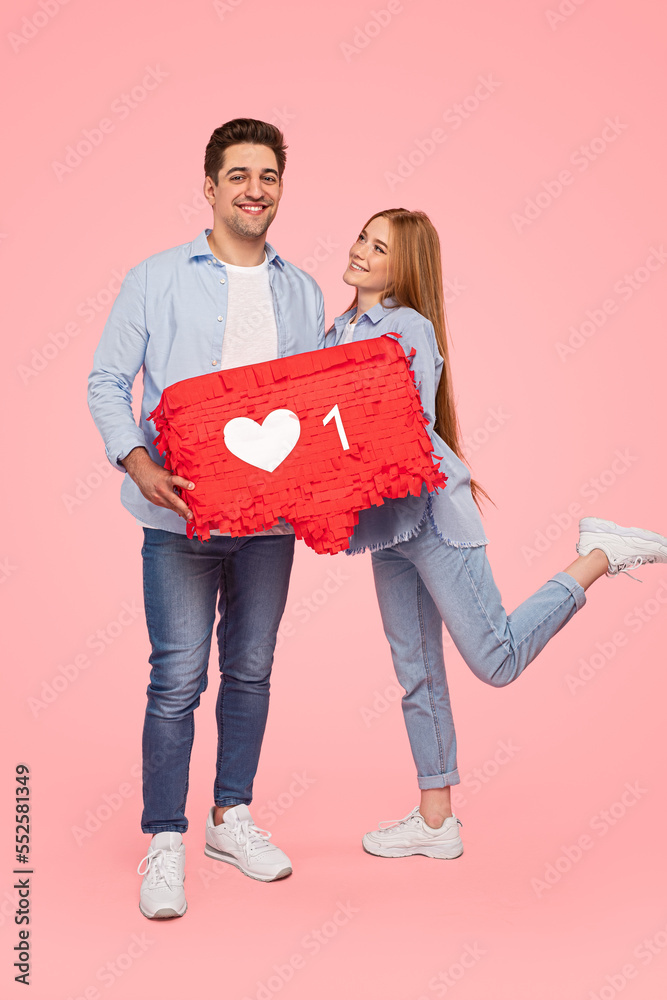 Young couple with like sign