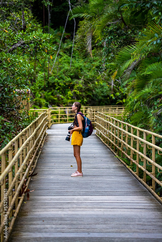 girl photographer looks out for animals while walking in manuel antonio national park near quepos, Costa Rica; wildlife photography in Costa Rican rainforests