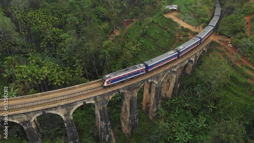 Wallpaper Mural Train crossing the Nine Arches Bridge in Sri Lanka (Ella) surrounded by lush green landscape, tea plantations and rolling hills. Drone footage 4K. Torontodigital.ca