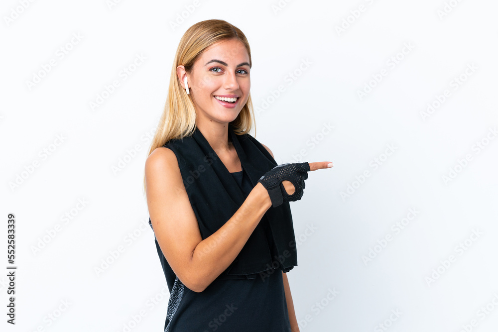 Blonde Uruguayan sport girl isolated on white background surprised and pointing side Blonde Uruguayan sport girl isolated on white background surprised and pointing side